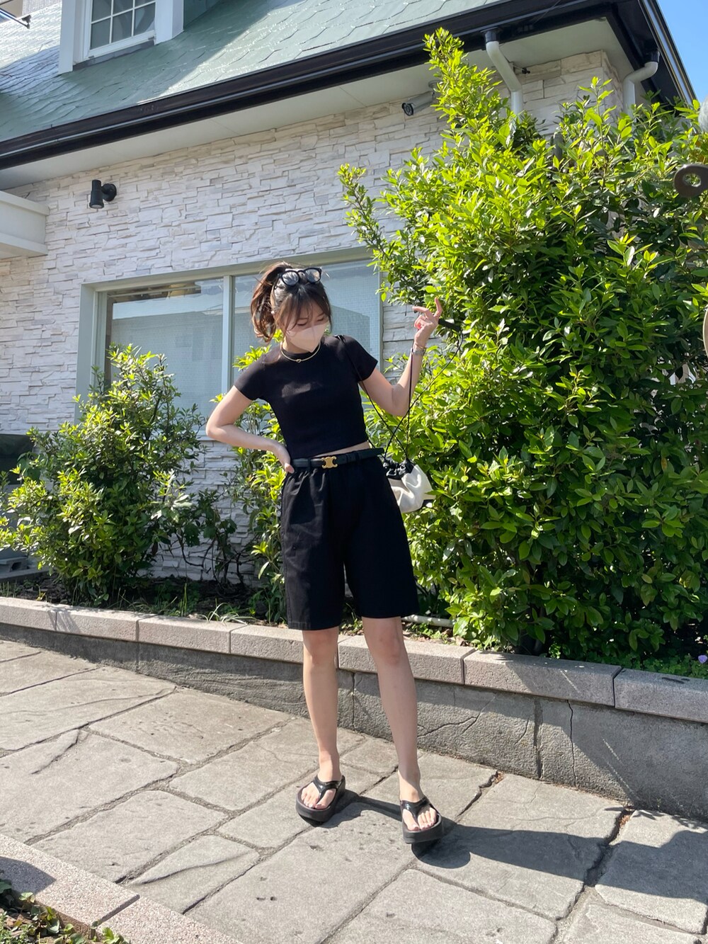 ブラック系のチノパンツ、ブラック系のサンダル、ブラック系のTシャツ/カットソーを着用したレディースの春コーディネートの3枚目の写真