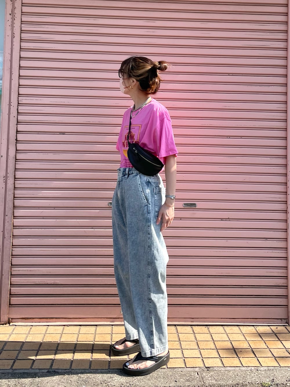 ブルー系のデニムパンツ、ピンク系のTシャツ/カットソー、ブラック系のボディバッグ/ウエストポーチを着用したレディースの春コーディネートの2枚目の写真