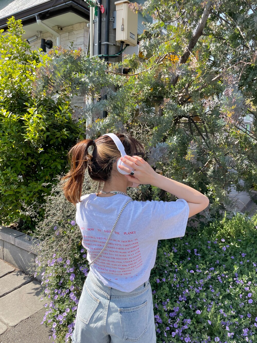 グレー系のTシャツ/カットソー、ブルー系のデニムパンツ、ホワイト系のスニーカーを着用したレディースの春コーディネートの3枚目の写真