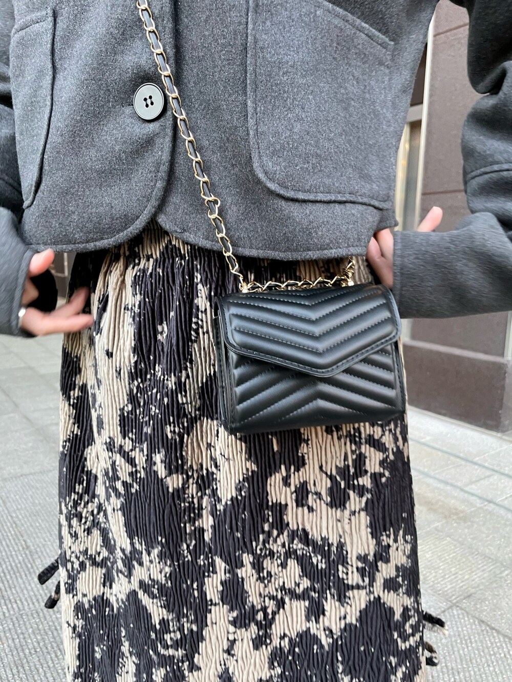 グレー系のジャケット/アウター、ブラック系のバッグ、ブラック系のスカートを着用したレディースの春コーディネートの3枚目の写真