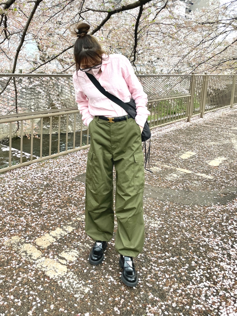 グリーン系のカーゴパンツ、ブラック系のバッグ、ピンク系のシャツ/ブラウスを着用したレディースの春コーディネートの2枚目の写真
