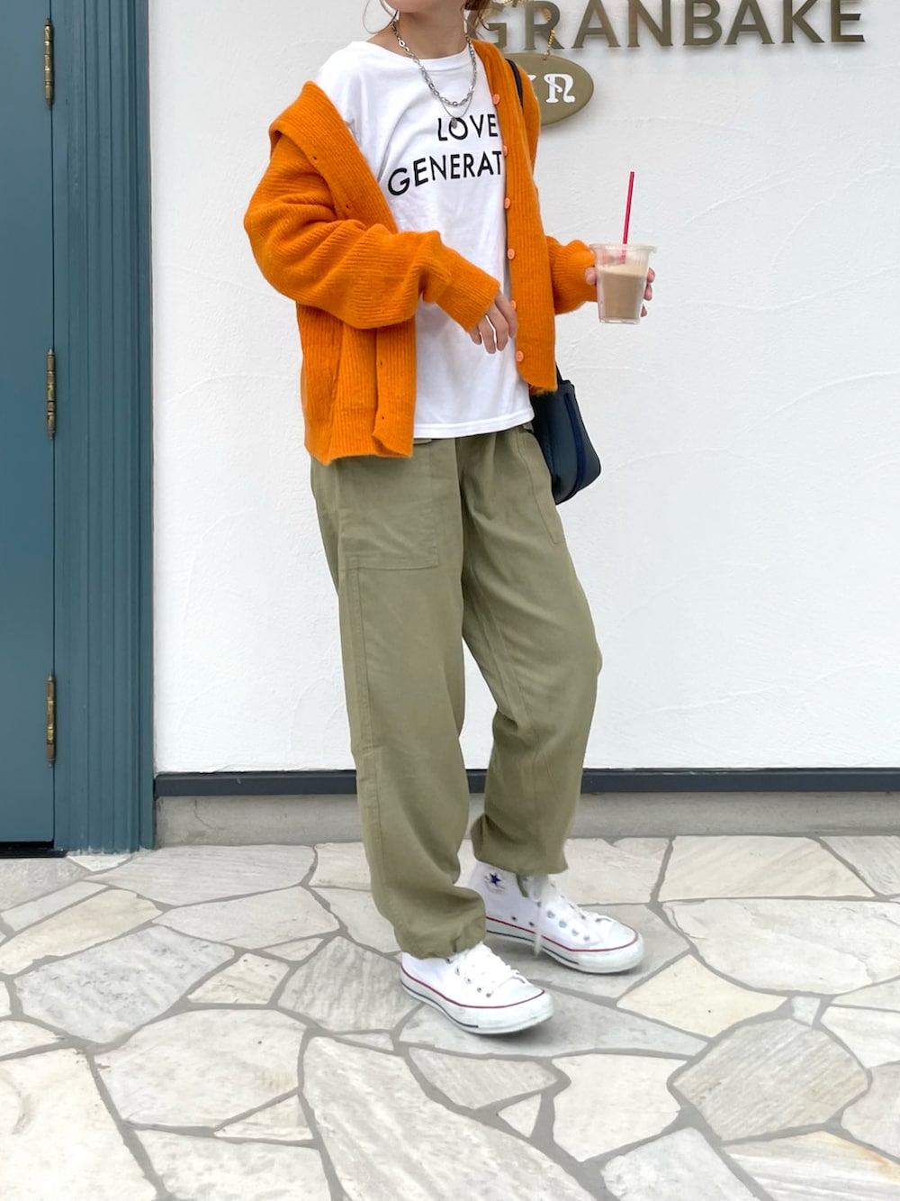 グリーン系のカーゴパンツ、ホワイト系のスニーカー、ホワイト系のTシャツ/カットソーを着用したレディースの秋コーディネートの3枚目の写真