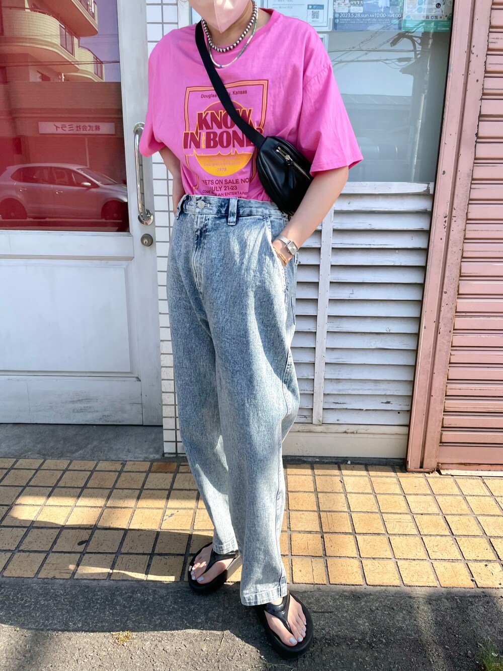 ブルー系のデニムパンツ、ピンク系のTシャツ/カットソー、ブラック系のボディバッグ/ウエストポーチを着用したレディースの春コーディネートの3枚目の写真