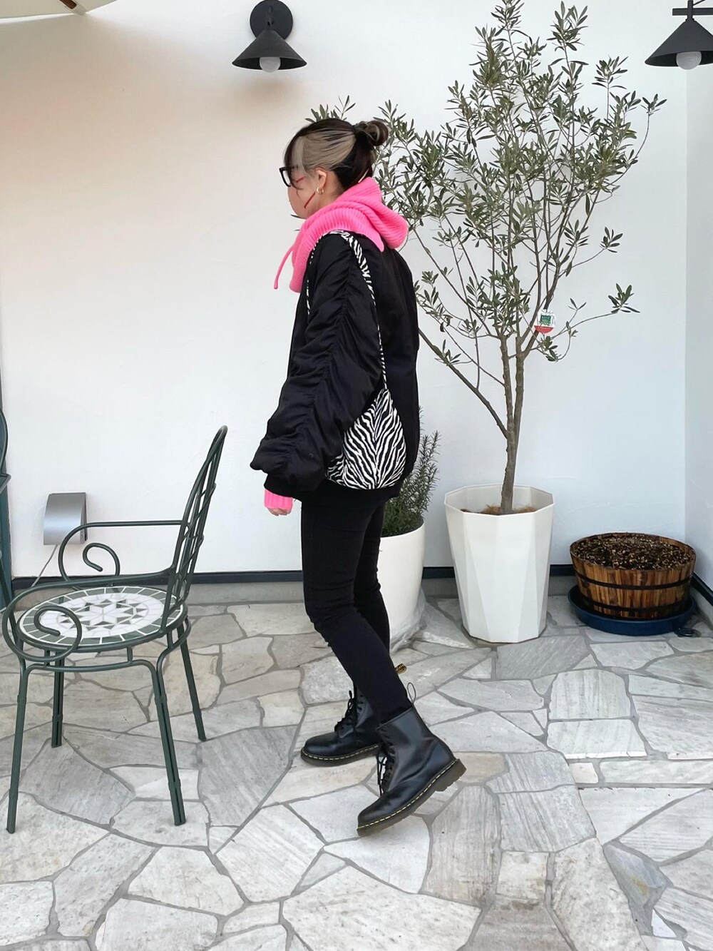 ブラック系のスウェット、ブラック系のブーツ、ピンク系のアームカバーを着用したレディースの冬コーディネートの3枚目の写真