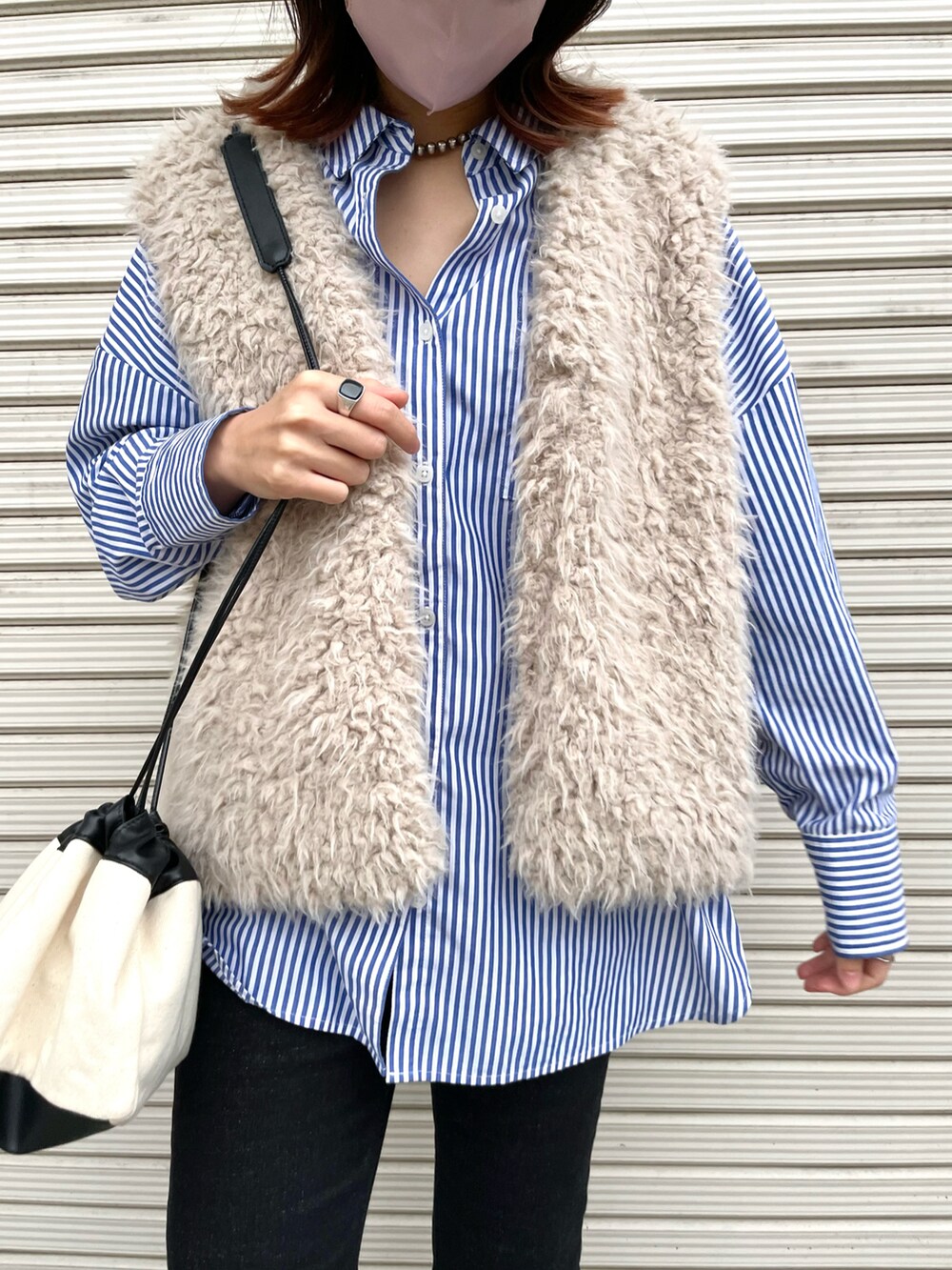 ブルー系のシャツ/ブラウス、ベージュ系のベスト、ブラック系のブーツを着用したレディースの秋コーディネートの3枚目の写真