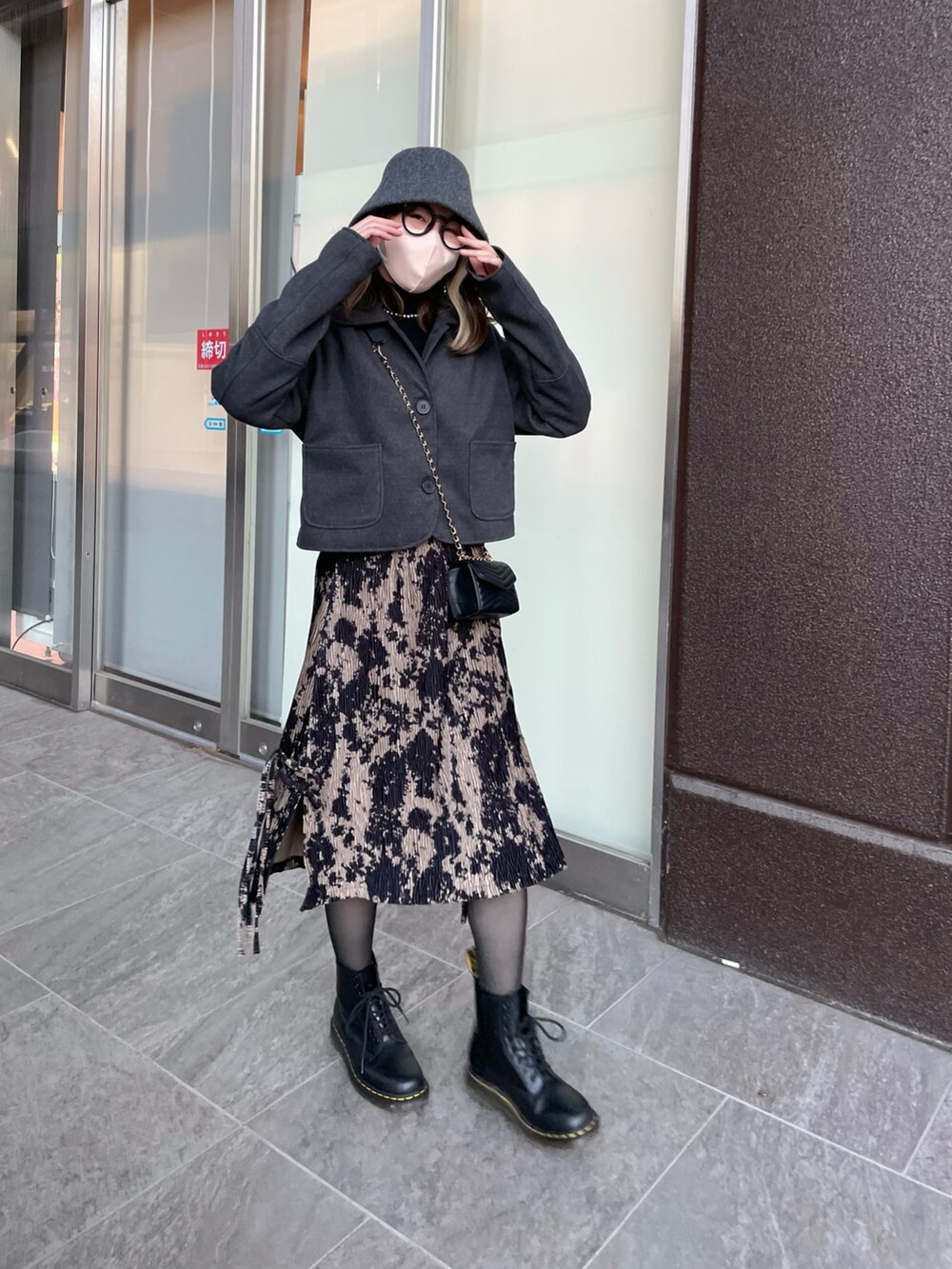 グレー系のジャケット/アウター、ブラック系のバッグ、ブラック系のスカートを着用したレディースの春コーディネートの2枚目の写真