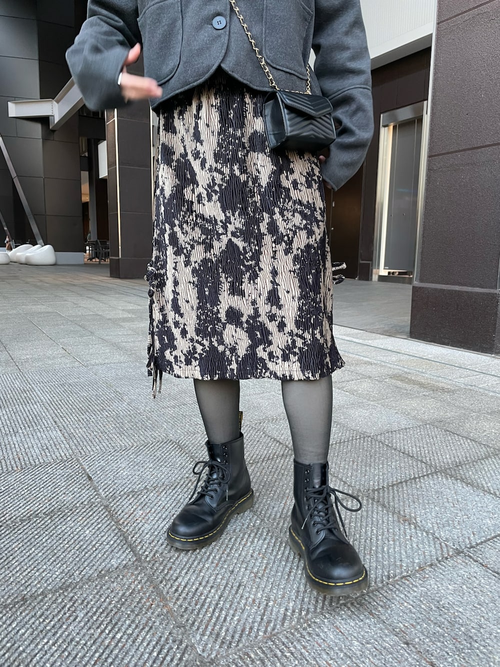 グレー系のジャケット/アウター、ブラック系のバッグ、ブラック系のスカートを着用したレディースの春コーディネートの4枚目の写真