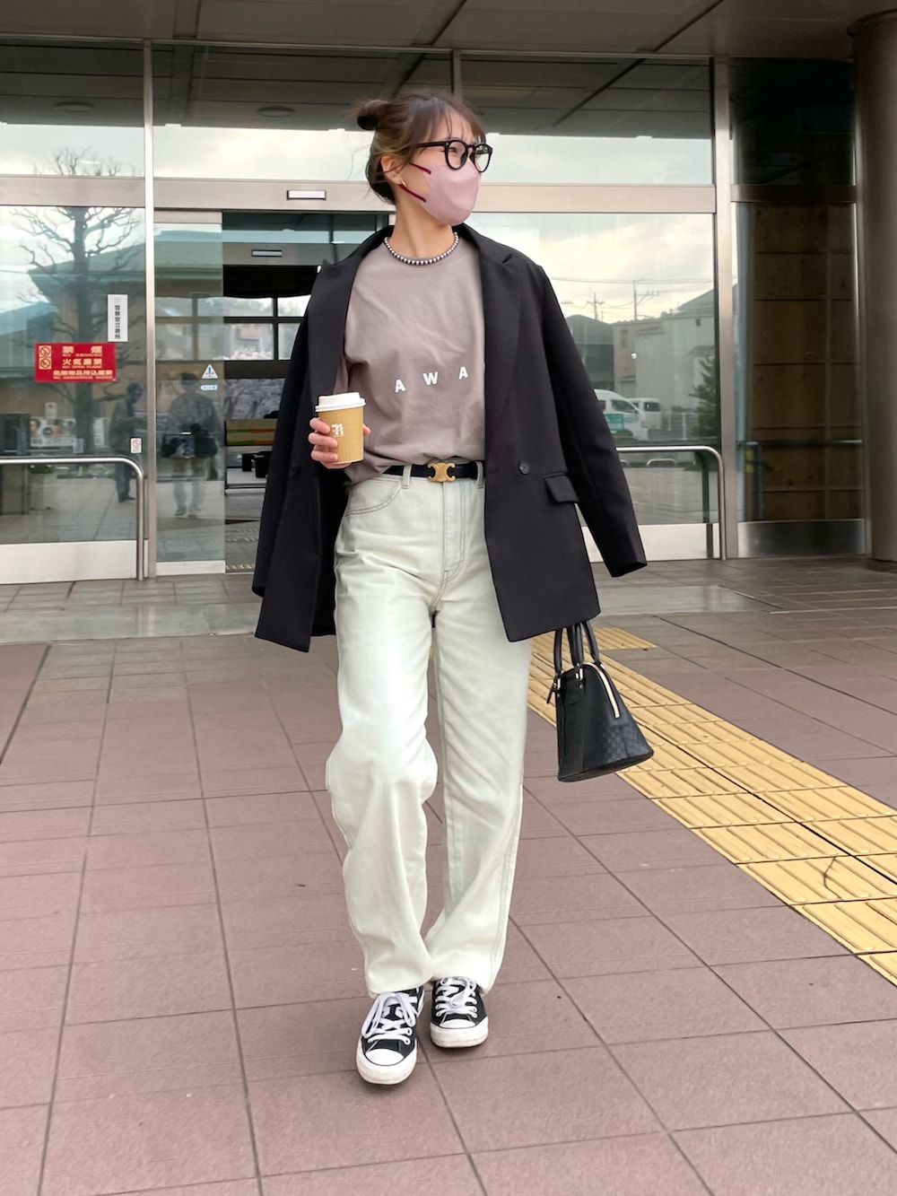 ブルー系のデニムパンツ、ベージュ系のTシャツ/カットソー、ブラック系のバッグを着用したレディースの春コーディネートの4枚目の写真