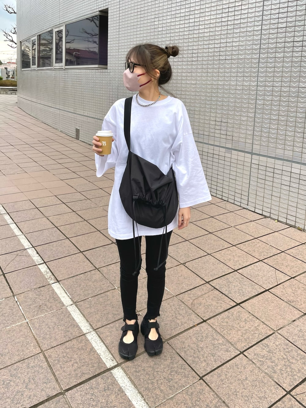 ブラック系のバッグ、ブラック系のサンダル、ホワイト系のTシャツ/カットソーを着用したレディースの春コーディネートの3枚目の写真