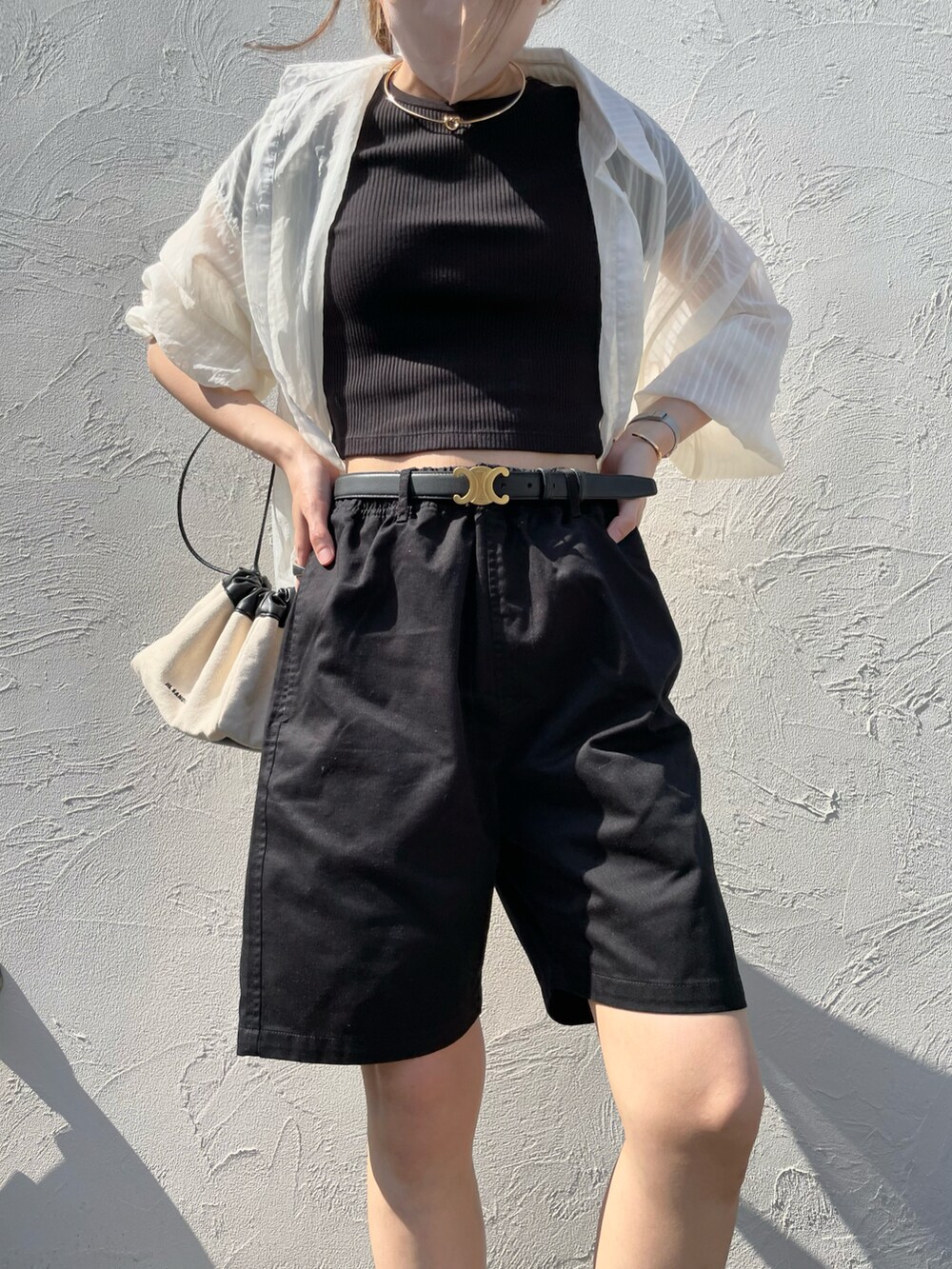 ブラック系のチノパンツ、ブラック系のサンダル、ブラック系のTシャツ/カットソーを着用したレディースの春コーディネートの2枚目の写真