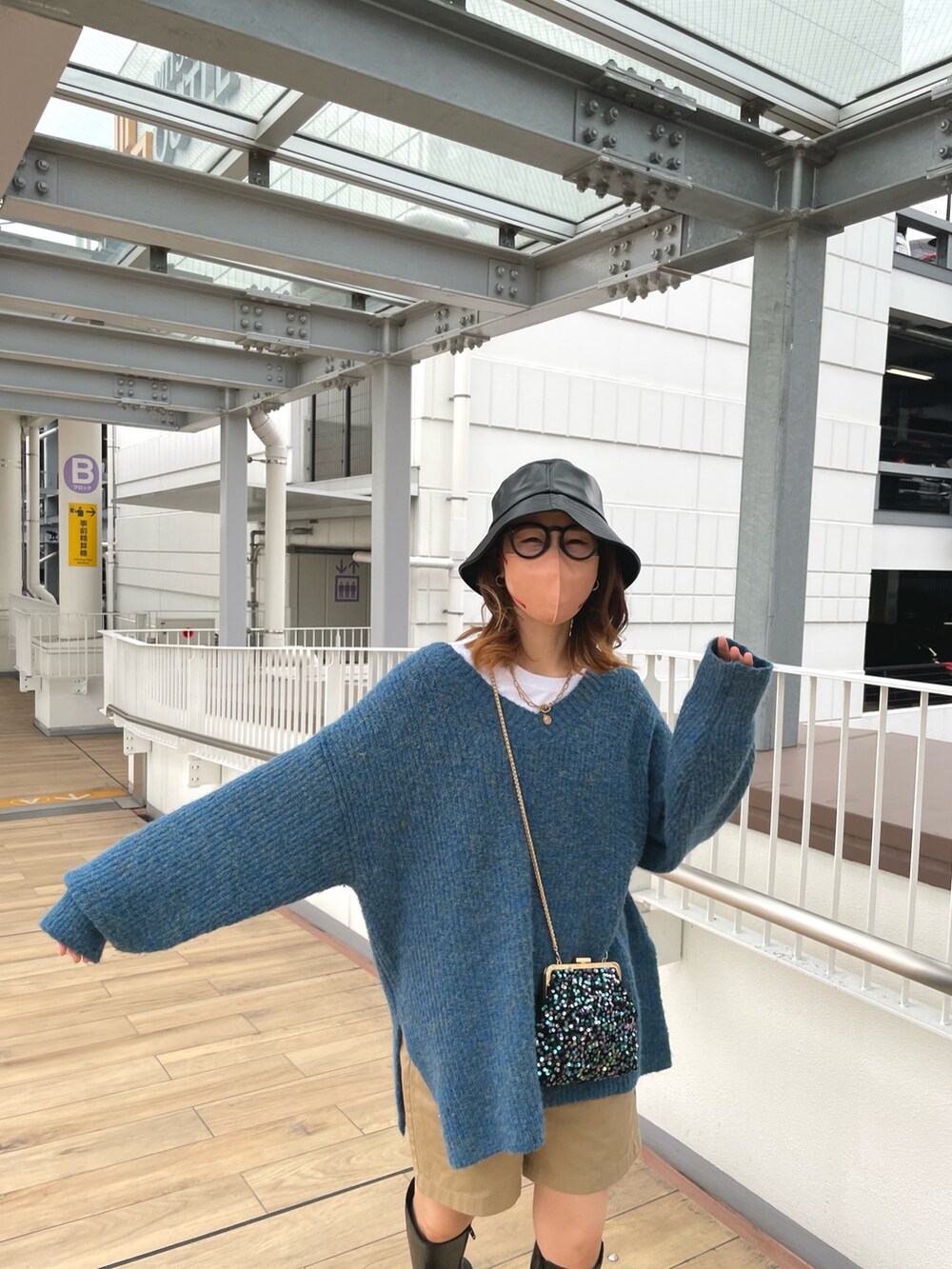 ブルー系のニット/セーター、ベージュ系のパンツ、ブラック系のブーツを着用したレディースの冬コーディネートの2枚目の写真