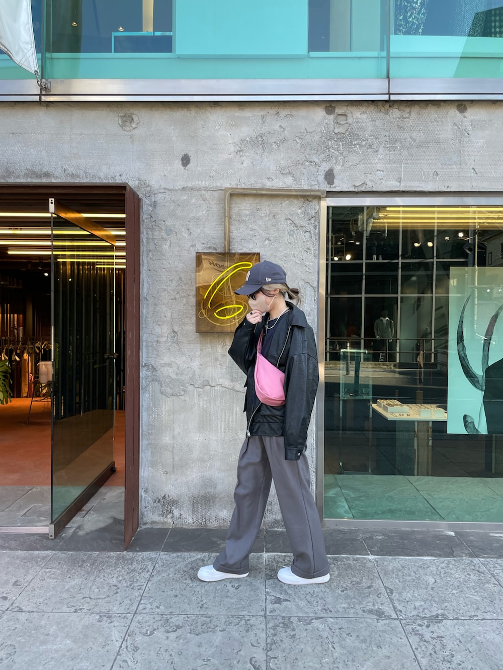 グレー系のパンツ、ピンク系のバッグ、ブラック系のブルゾンを着用したレディースの冬コーディネートの3枚目の写真