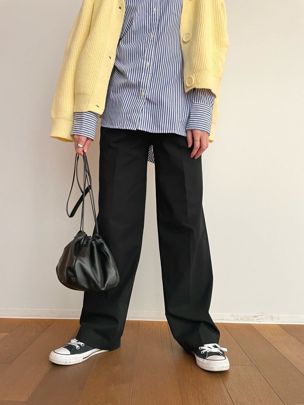 ブラック系のパンツ、ブルー系のシャツ/ブラウス、イエロー系のカーディガン/ボレロを着用したレディースの春コーディネートの3枚目の写真