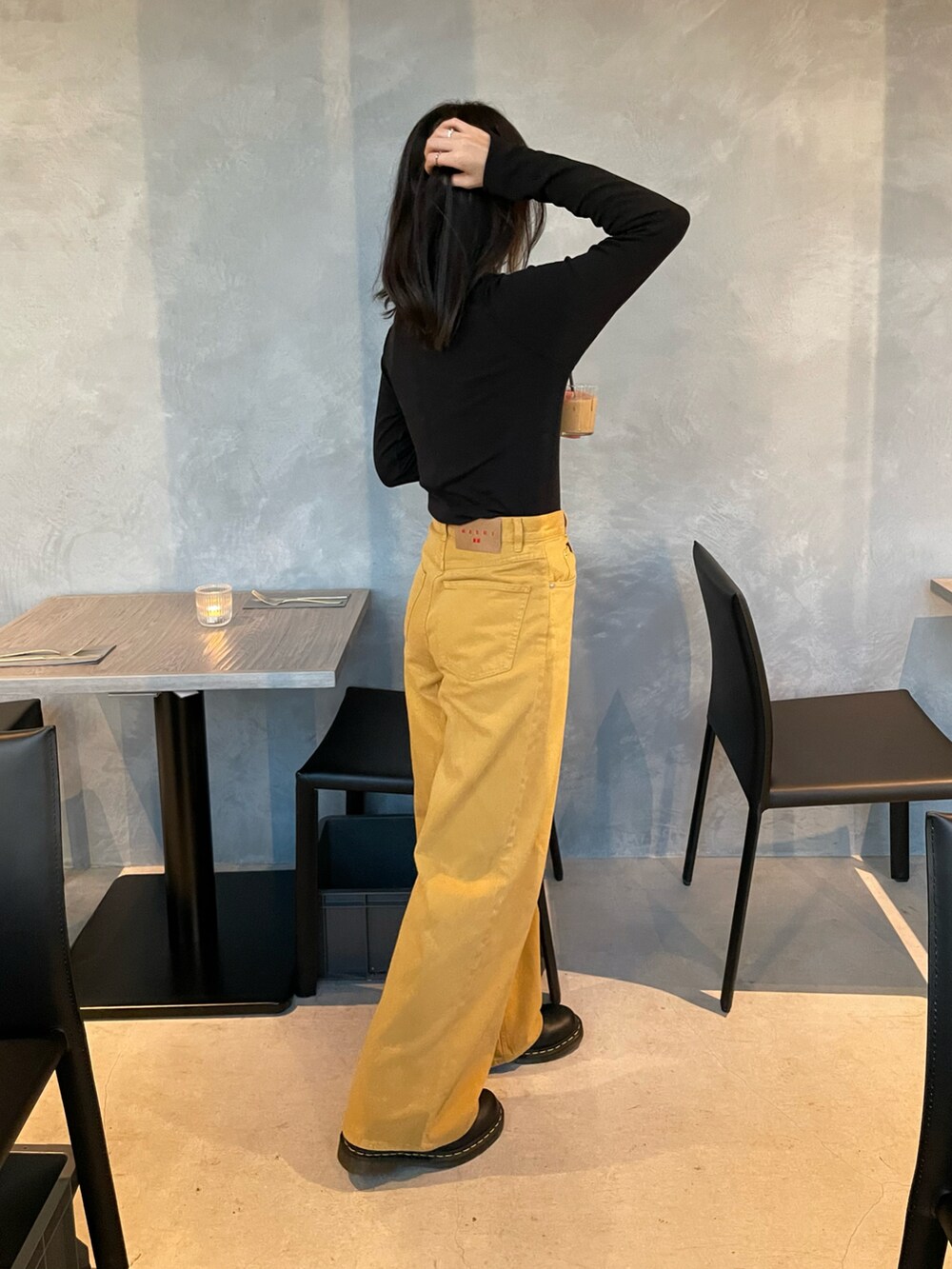 イエロー系のパンツ、ブラック系のMA-1、ブラック系のトップスを着用したレディースの春コーディネートの3枚目の写真