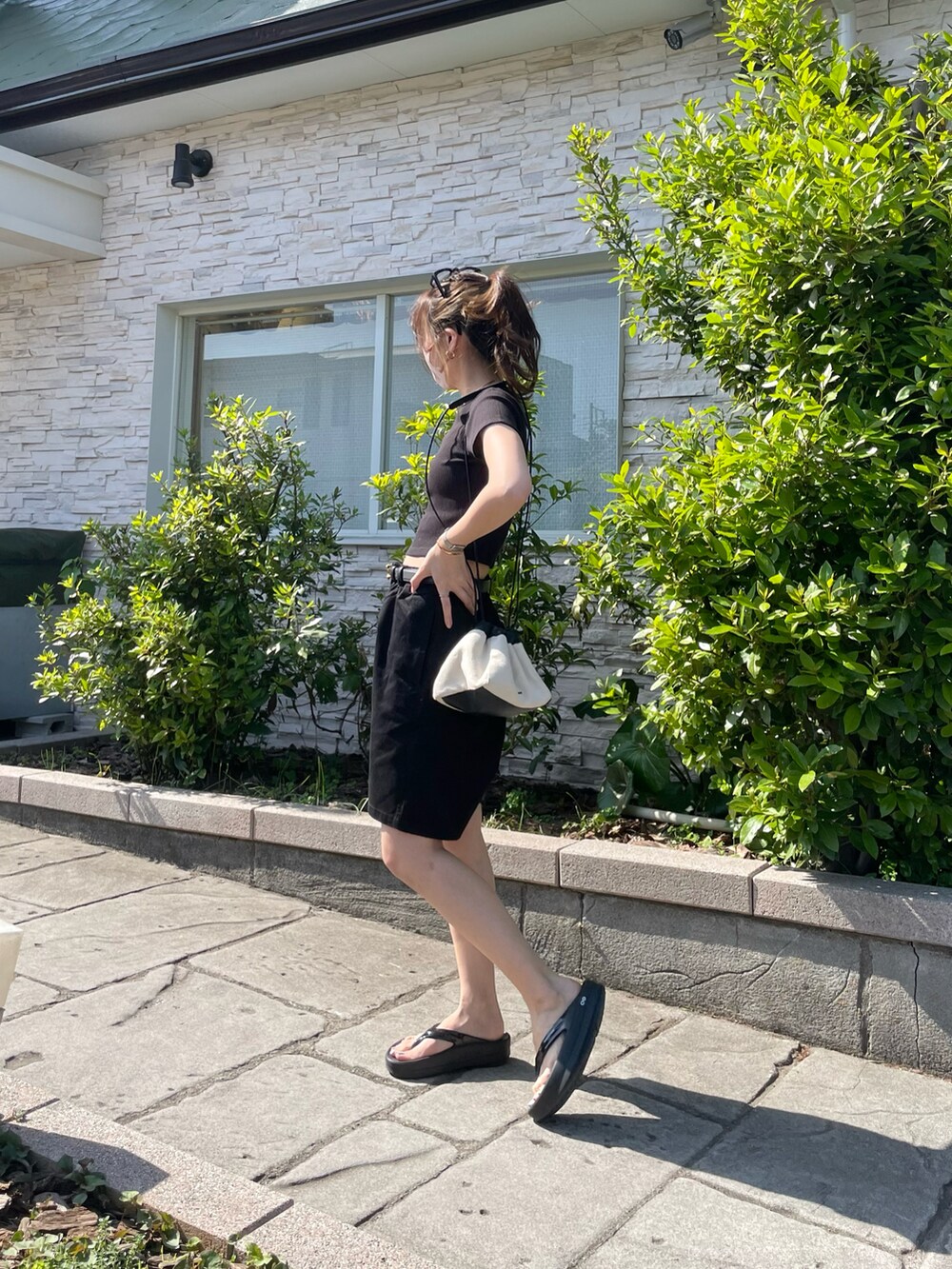 ブラック系のチノパンツ、ブラック系のサンダル、ブラック系のTシャツ/カットソーを着用したレディースの春コーディネートの4枚目の写真