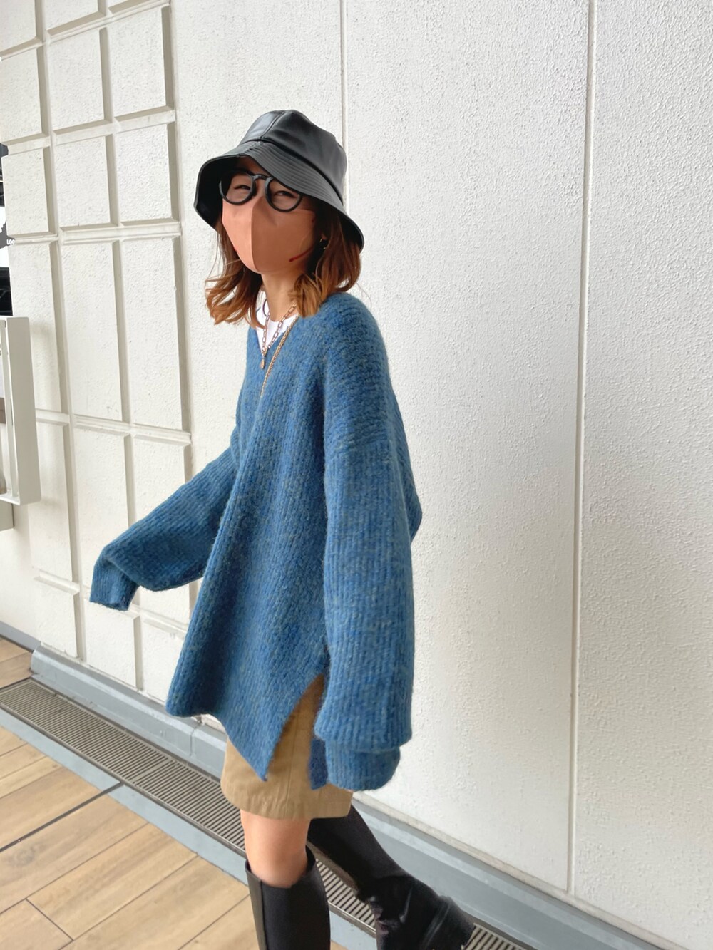ブルー系のニット/セーター、ベージュ系のパンツ、ブラック系のブーツを着用したレディースの冬コーディネートの3枚目の写真