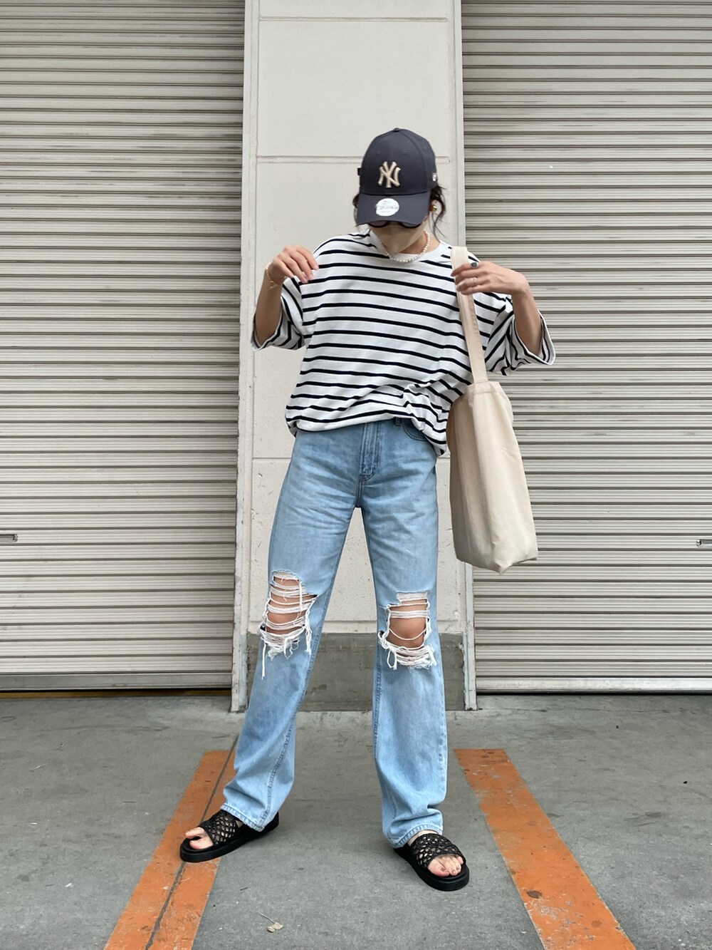 ブルー系のデニムパンツ、ブルー系のTシャツ/カットソー、ホワイト系のトートバッグを着用したレディースの夏コーディネートの3枚目の写真