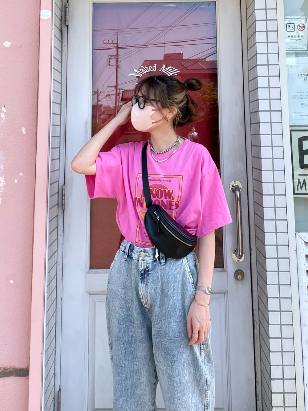 ブルー系のデニムパンツ、ピンク系のTシャツ/カットソー、ブラック系のボディバッグ/ウエストポーチを着用したレディースの春コーディネートの4枚目の写真