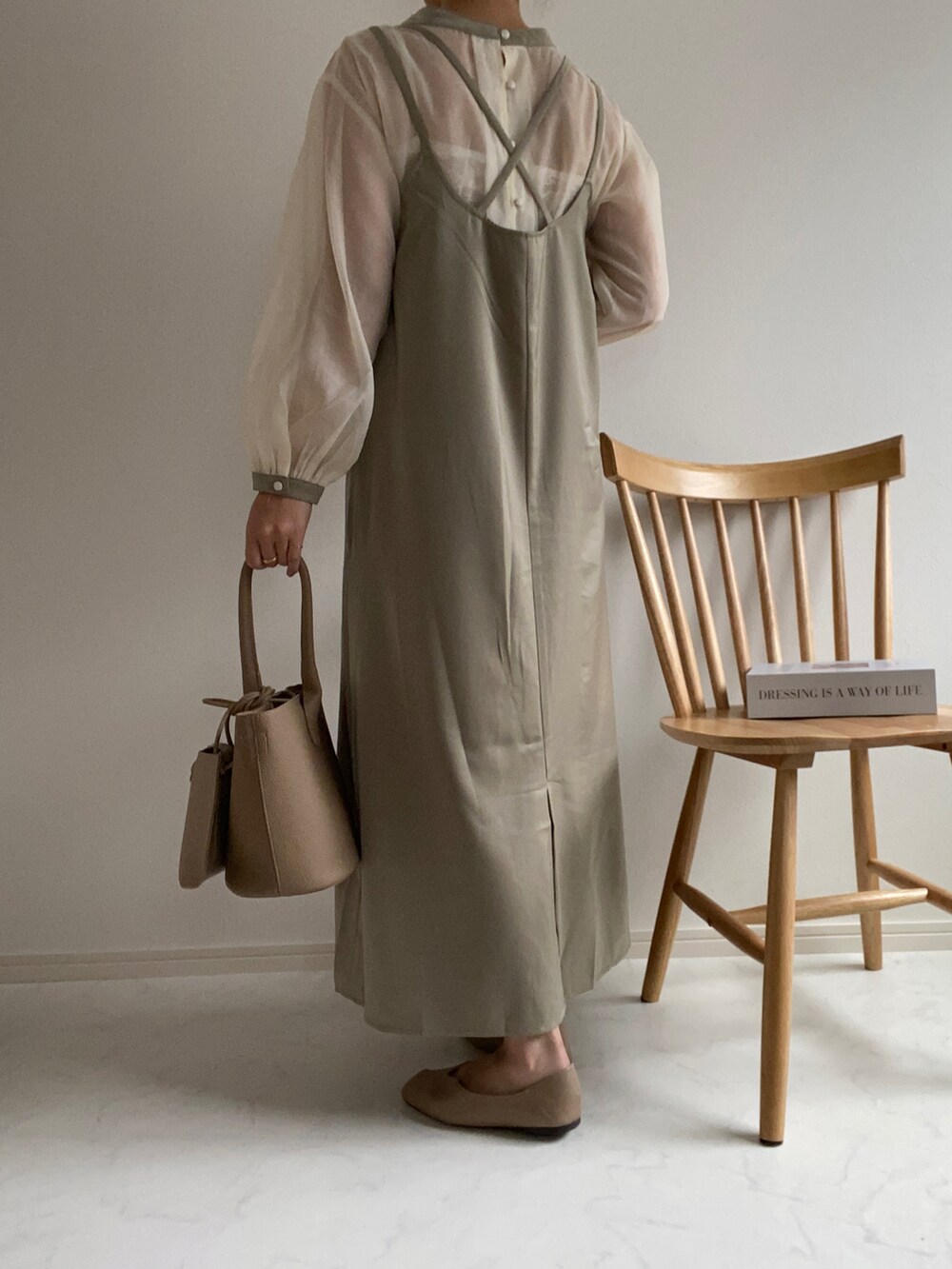 グリーン系のワンピース、グレー系のパンプス、その他のハンドバッグを着用したレディースの春コーディネートの3枚目の写真