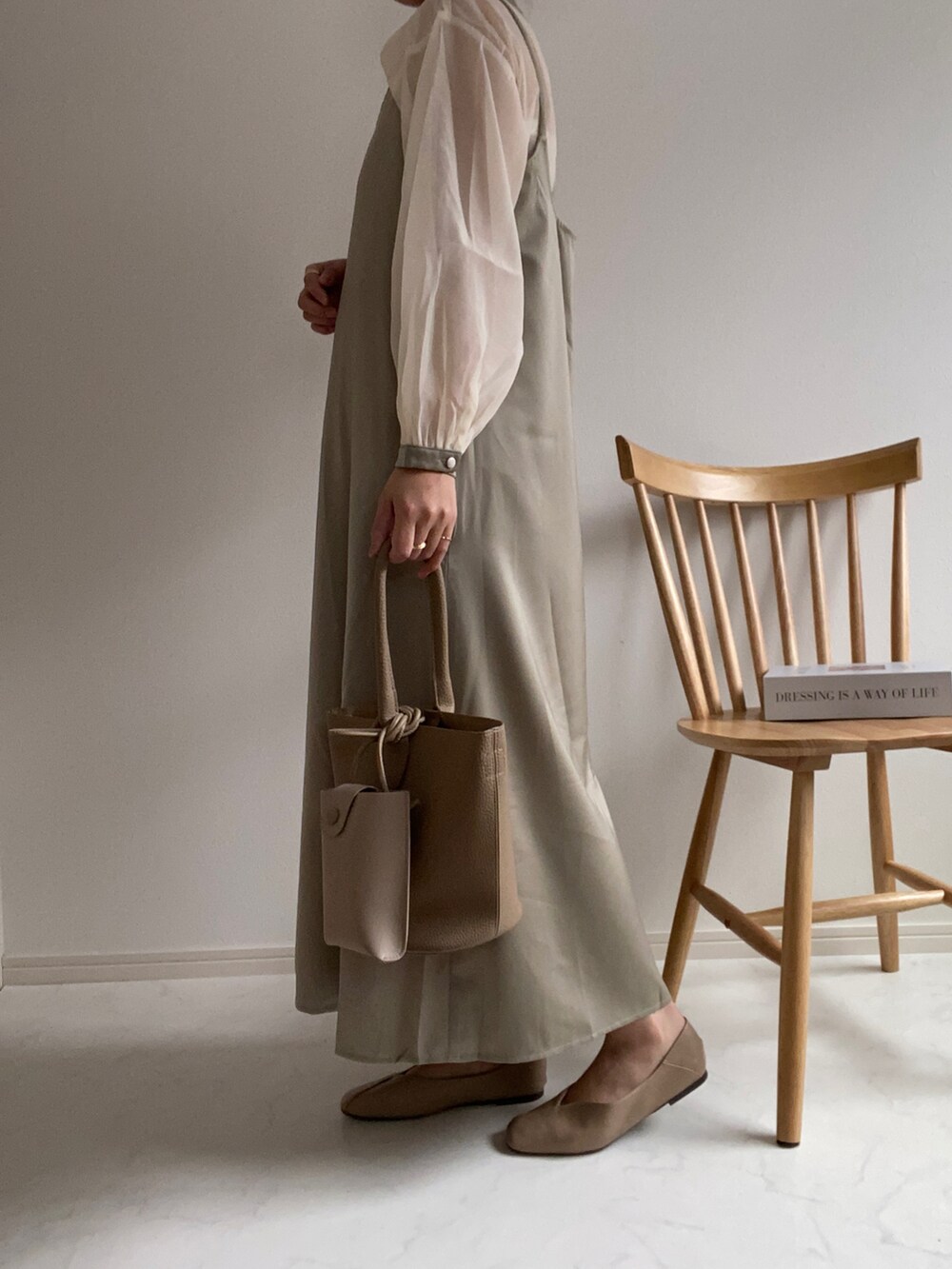 グリーン系のワンピース、グレー系のパンプス、その他のハンドバッグを着用したレディースの春コーディネートの2枚目の写真