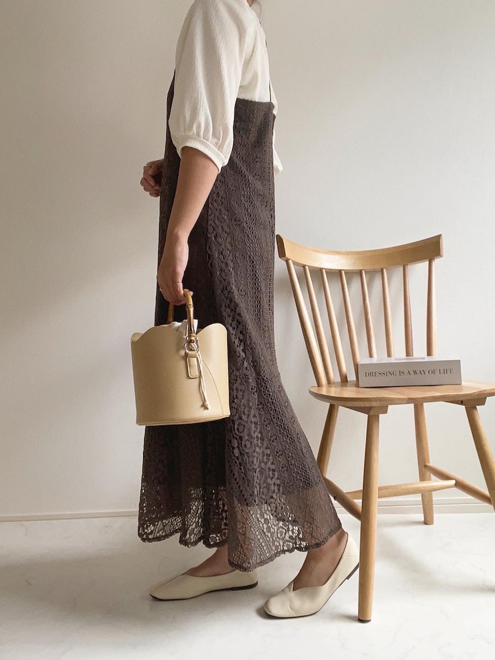 ホワイト系のTシャツ/カットソー、ベージュ系のハンドバッグ、ブラウン系のワンピースを着用したレディースの春コーディネートの2枚目の写真