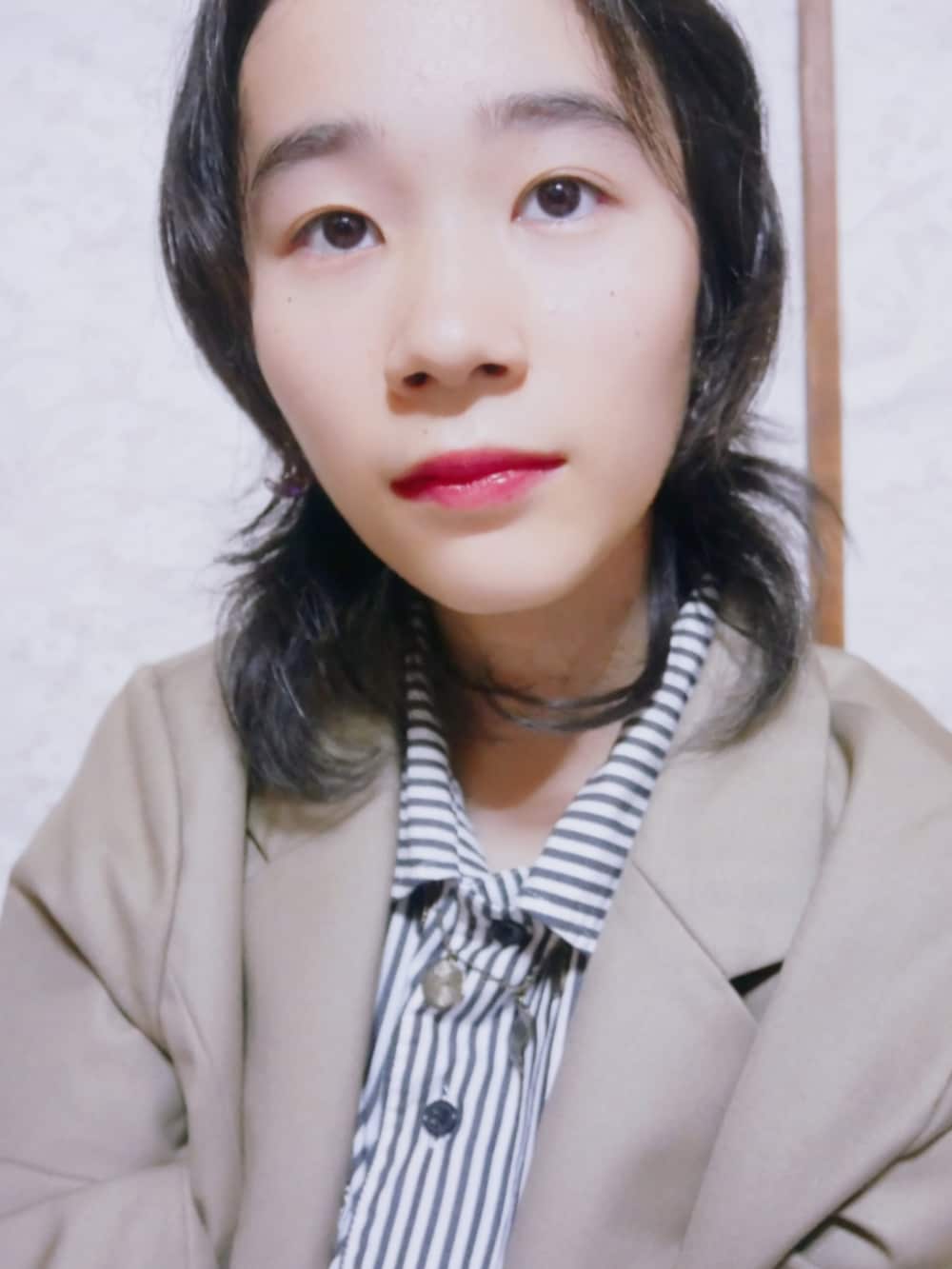 ベージュ系のテーラードジャケット、ブルー系のシャツ/ブラウス、パープル系のスカートを着用したレディースの秋コーディネートの3枚目の写真