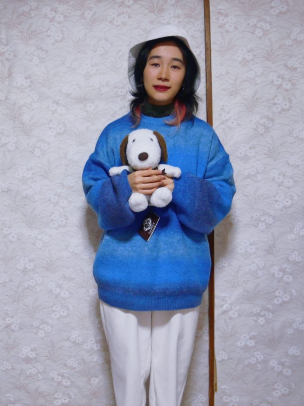 ブルー系のニット/セーター、ホワイト系のパンツ、ホワイト系の帽子を着用したレディースの秋コーディネートの2枚目の写真