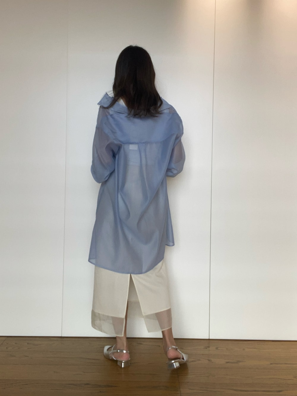 ブルー系のワンピース、シルバー系のハンドバッグ、ホワイト系のスカートを着用したレディースの春コーディネートの2枚目の写真