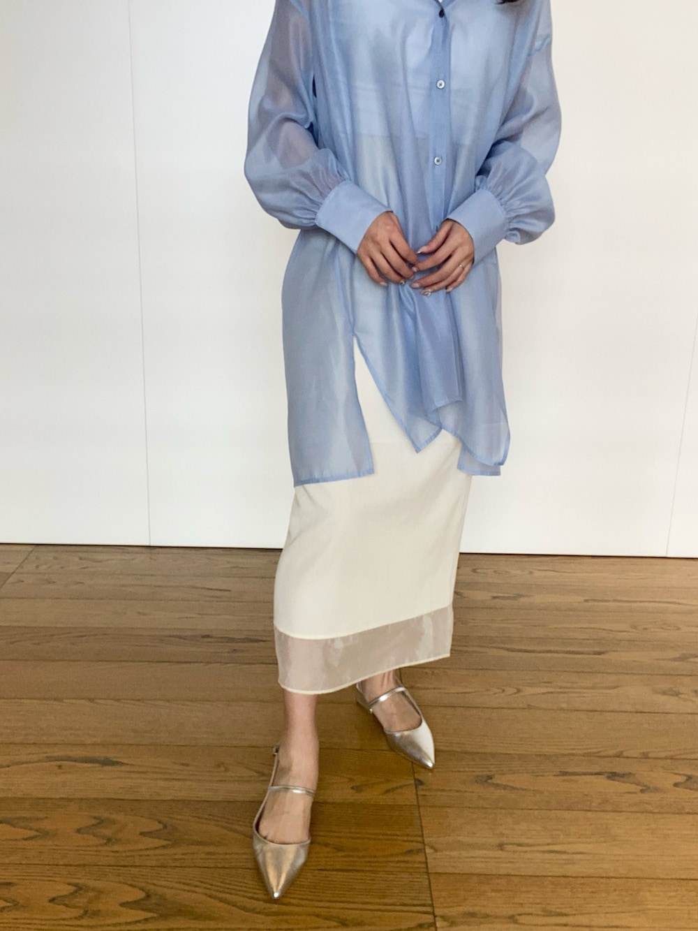 ブルー系のワンピース、シルバー系のハンドバッグ、ホワイト系のスカートを着用したレディースの春コーディネートの3枚目の写真