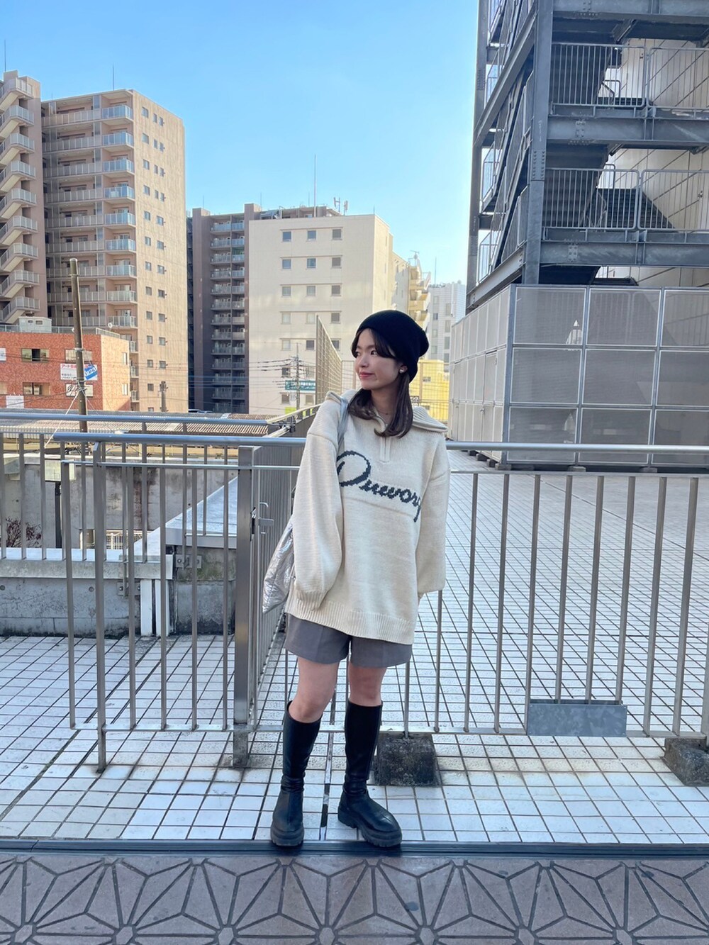 ホワイト系のニット/セーター、グレー系のその他パンツ、ブラック系のブーツを着用したレディースの秋コーディネートの2枚目の写真