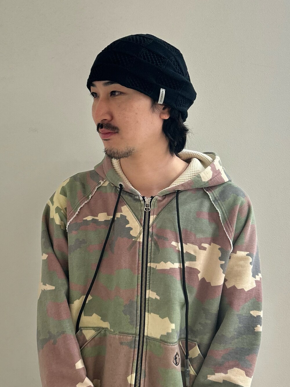 ブラック系のニットキャップ/ビーニーを着用したメンズの冬コーディネートの2枚目の写真