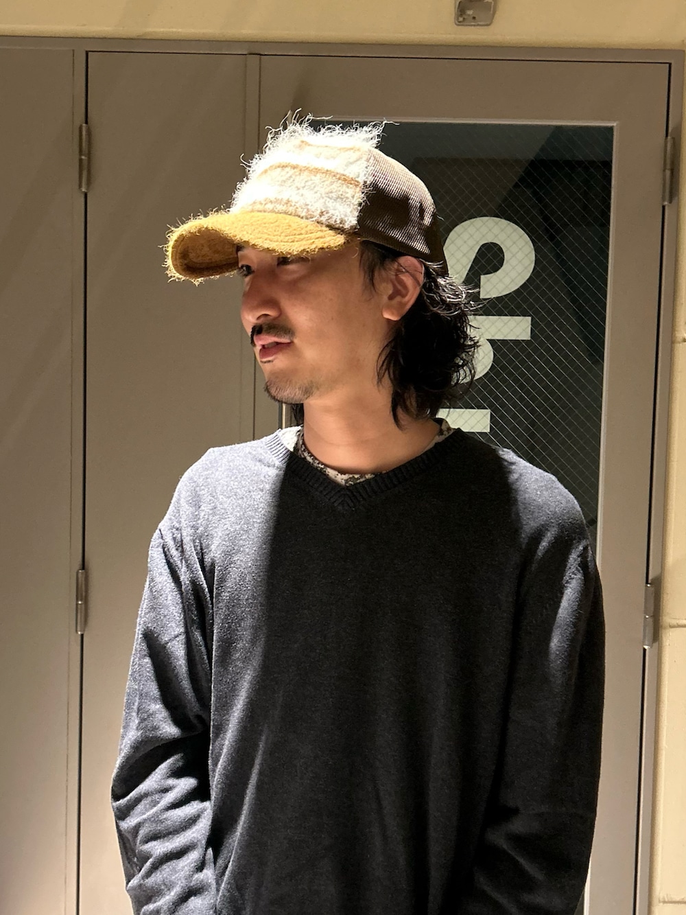 ブラウン系のキャップを着用したメンズの秋コーディネートの2枚目の写真