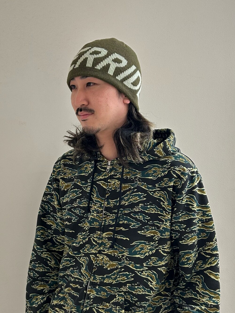 グリーン系のニットキャップ/ビーニーを着用したメンズの冬コーディネートの4枚目の写真