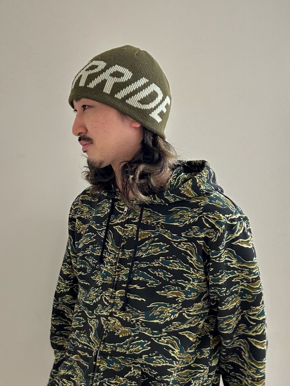 グリーン系のニットキャップ/ビーニーを着用したメンズの冬コーディネートの3枚目の写真