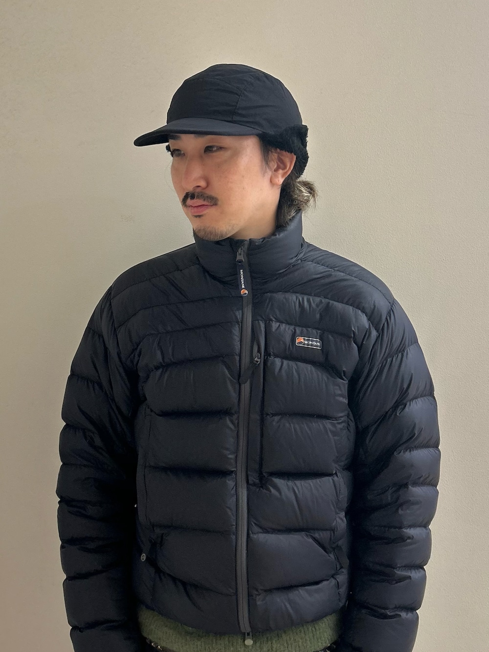 ブラック系のキャップを着用したメンズの冬コーディネートの2枚目の写真