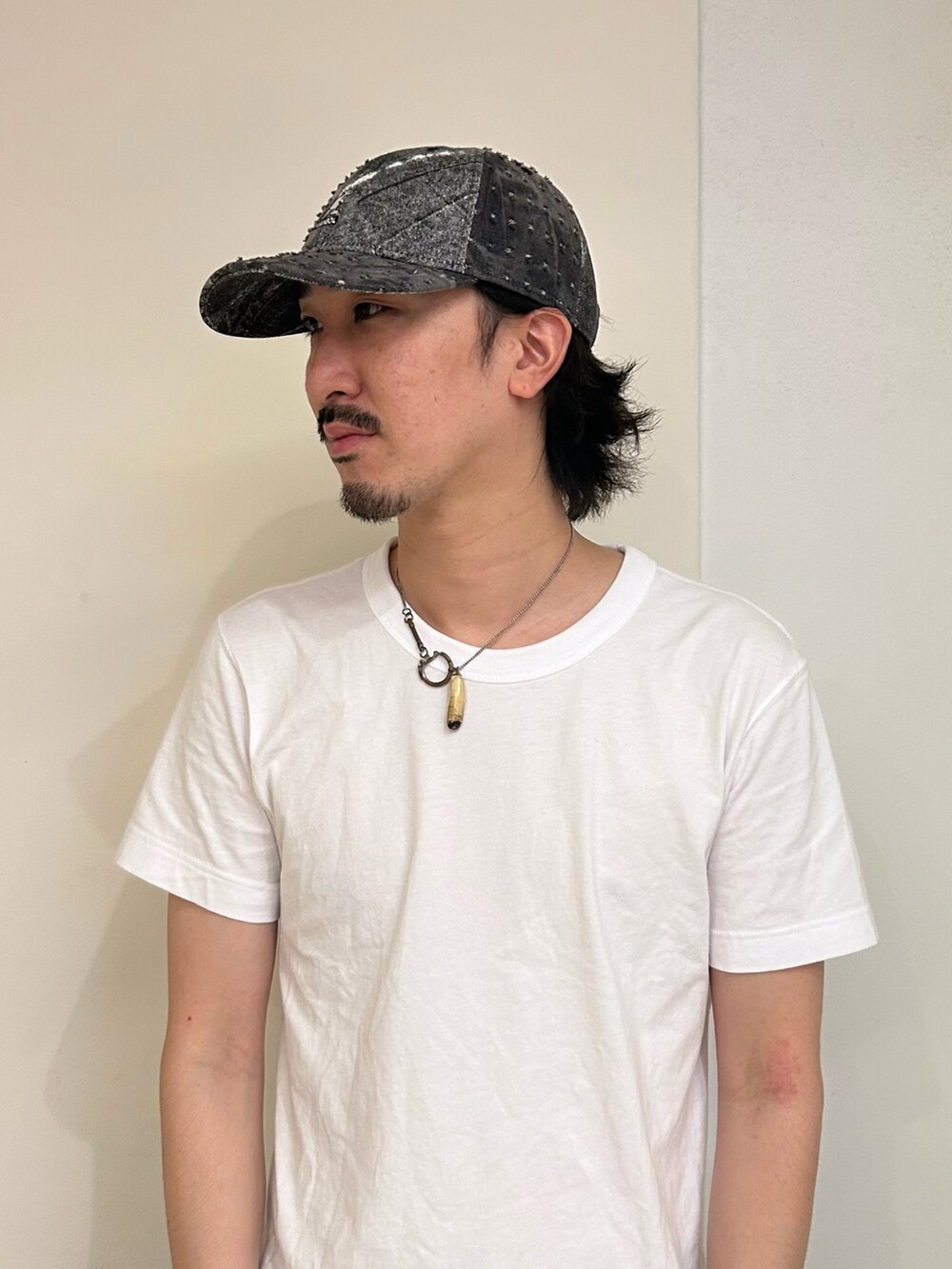 ブラック系のキャップを着用したメンズの夏コーディネートの2枚目の写真