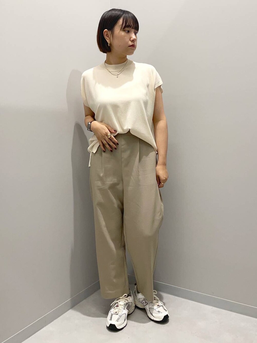 ベージュ系のその他パンツ、ホワイト系のニット/セーターを着用したレディースの夏コーディネートの2枚目の写真