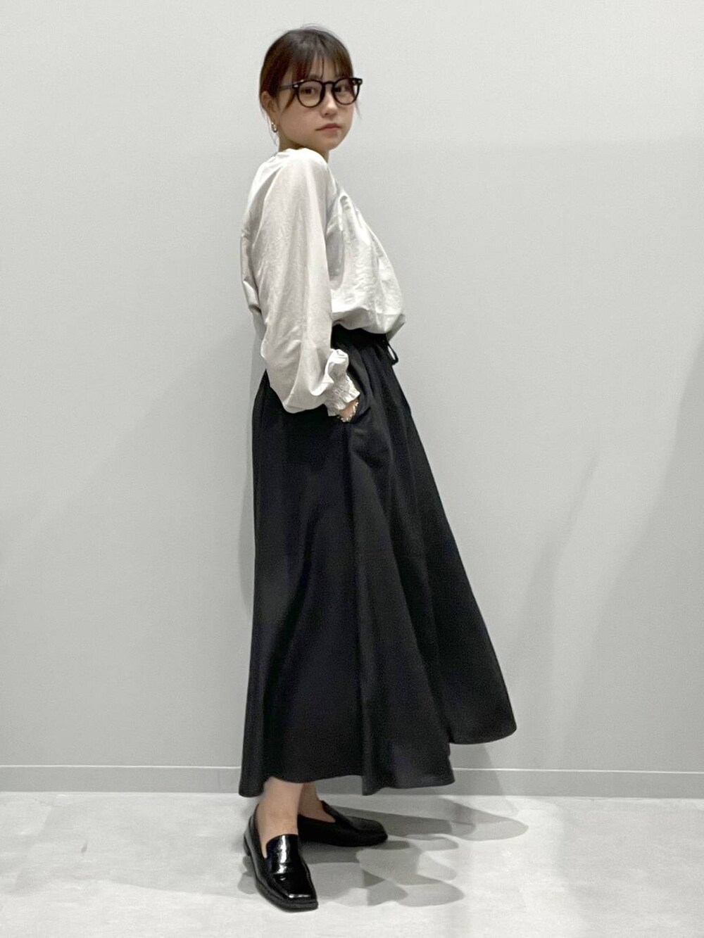 ブラック系のその他パンツ、グレー系のシャツ/ブラウスを着用したレディースの春コーディネートの2枚目の写真