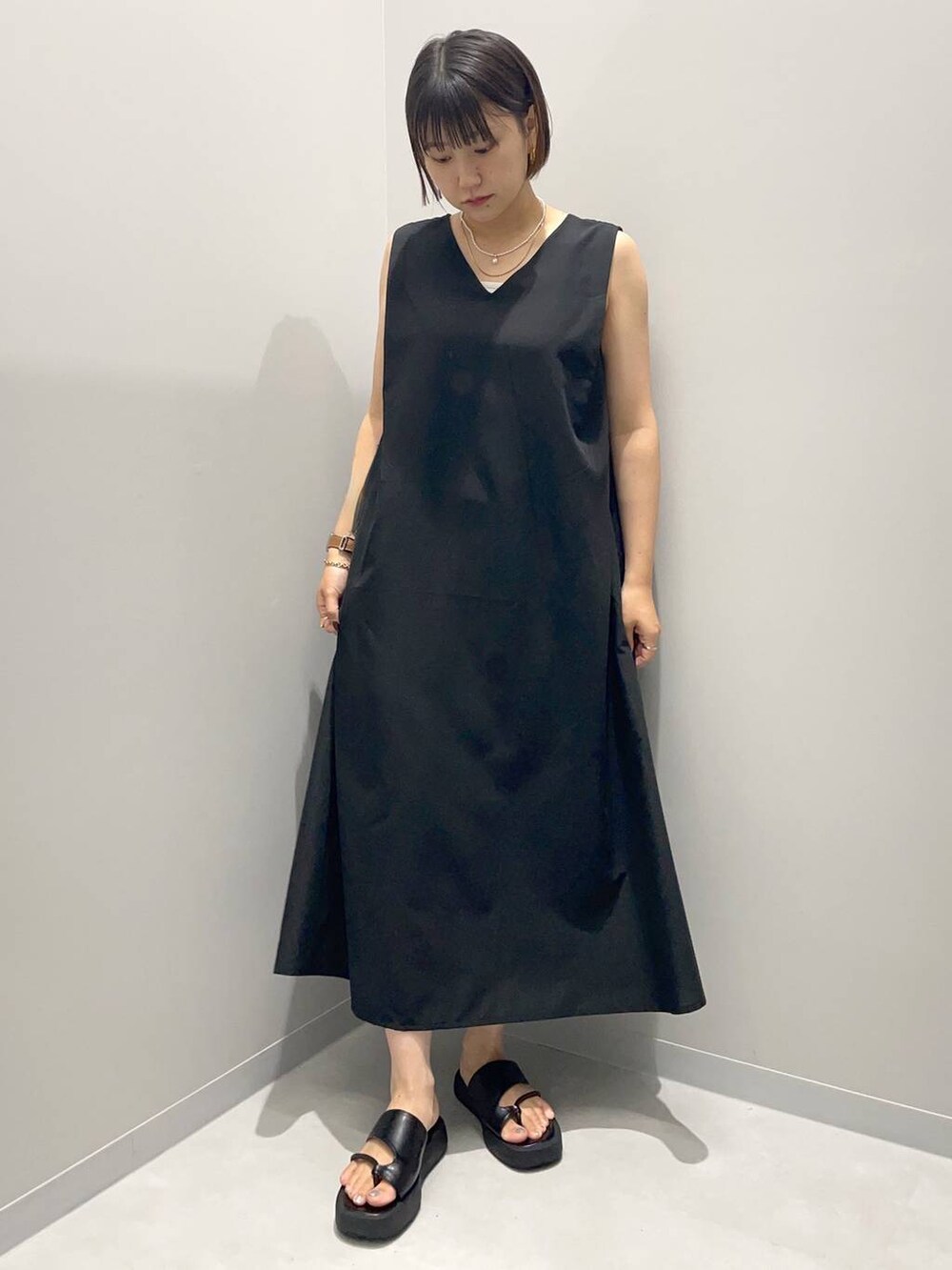 ブラック系のワンピースを着用したレディースの夏コーディネートの2枚目の写真