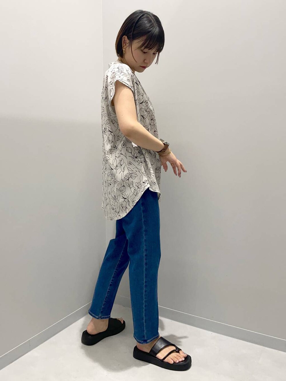 ブルー系のデニムパンツ、ホワイト系のシャツ/ブラウスを着用したレディースの夏コーディネートの2枚目の写真