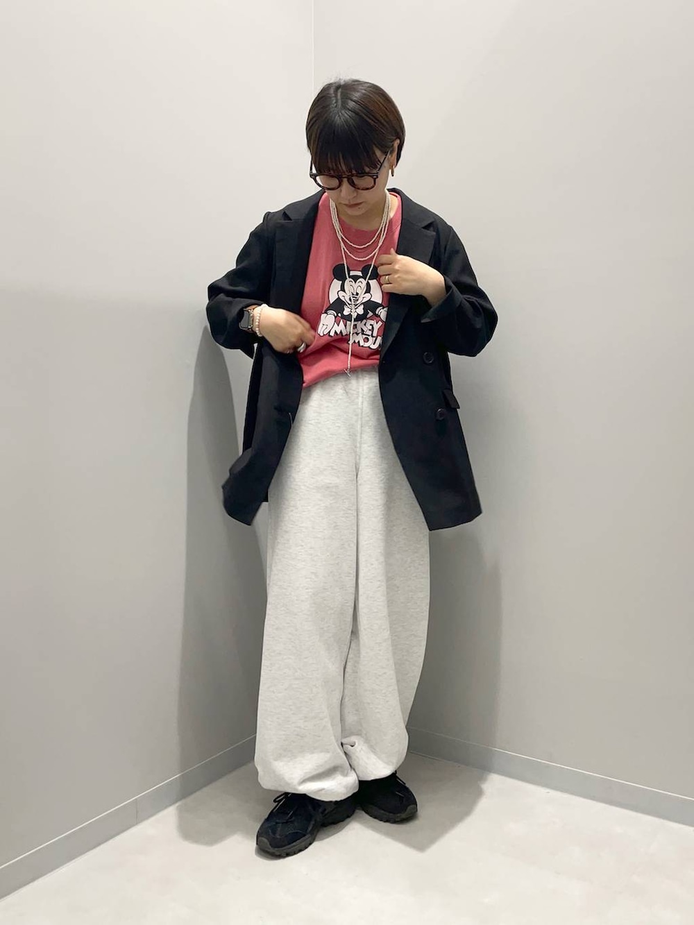 ブラック系のテーラードジャケット、グレー系のスウェットパンツ、レッド系のTシャツ/カットソーを着用したレディースの春コーディネートの2枚目の写真