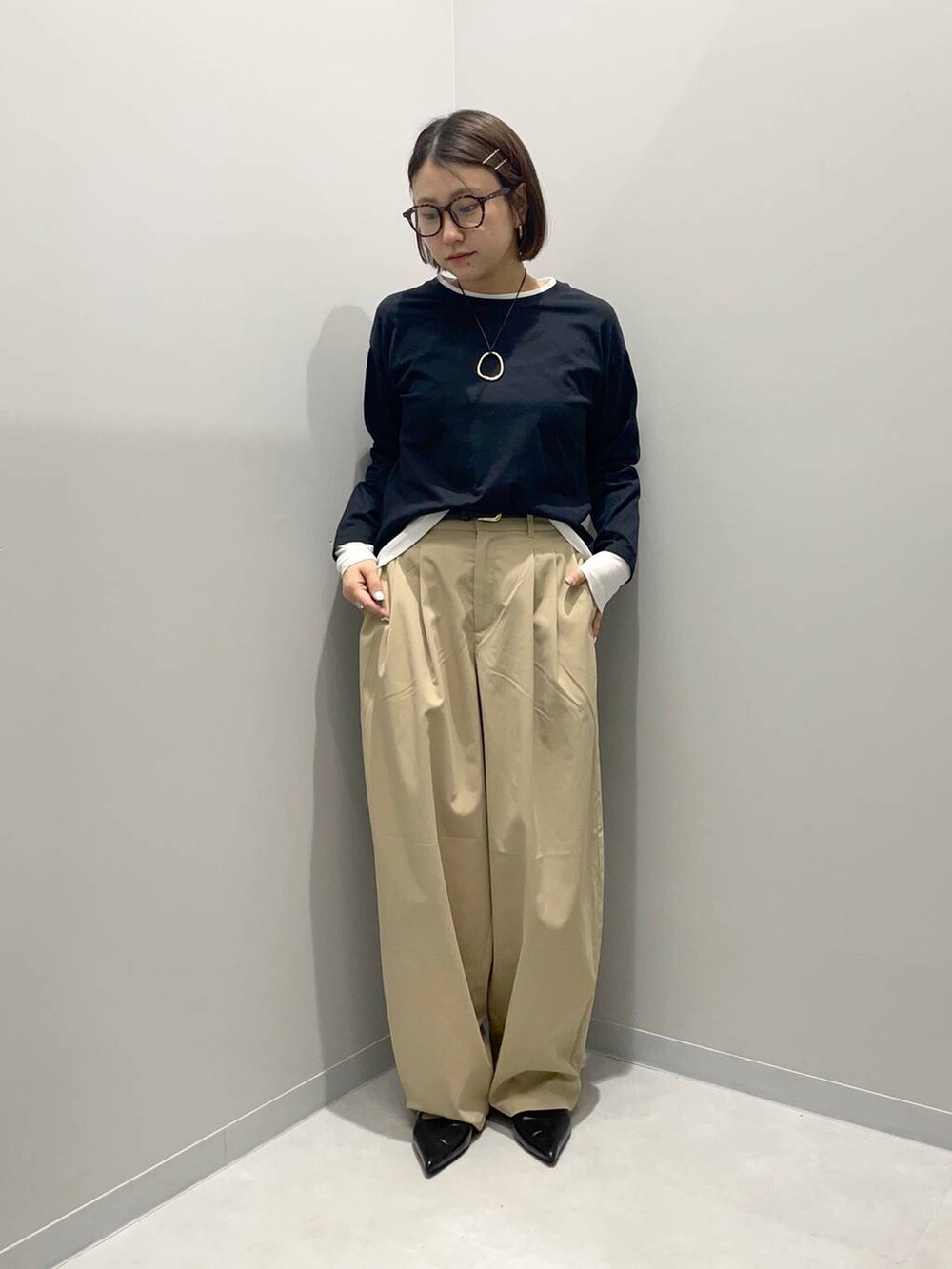 ベージュ系のその他パンツ、ブラック系のTシャツ/カットソー、イエロー系のネックレスを着用したレディースの春コーディネートの2枚目の写真