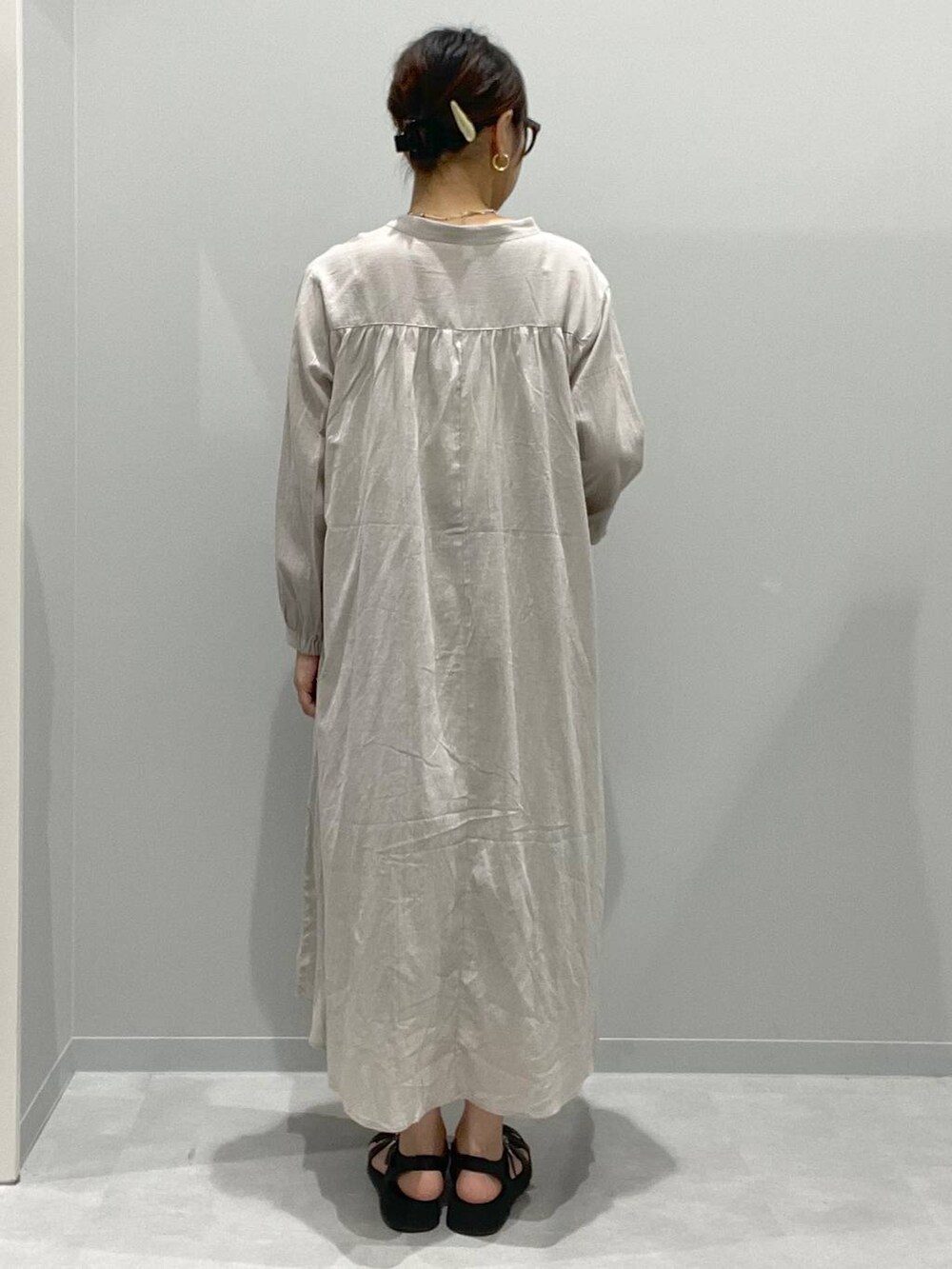 ベージュ系のシャツワンピース、ホワイト系のネックレスを着用したレディースの春コーディネートの3枚目の写真