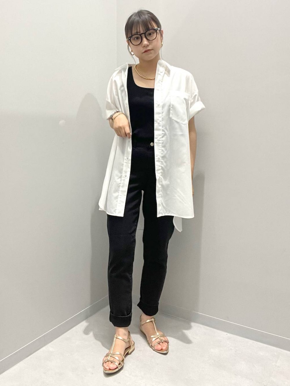 ホワイト系のシャツ/ブラウス、ブラック系のデニムパンツ、イエロー系のネックレスを着用したレディースの夏コーディネートの2枚目の写真