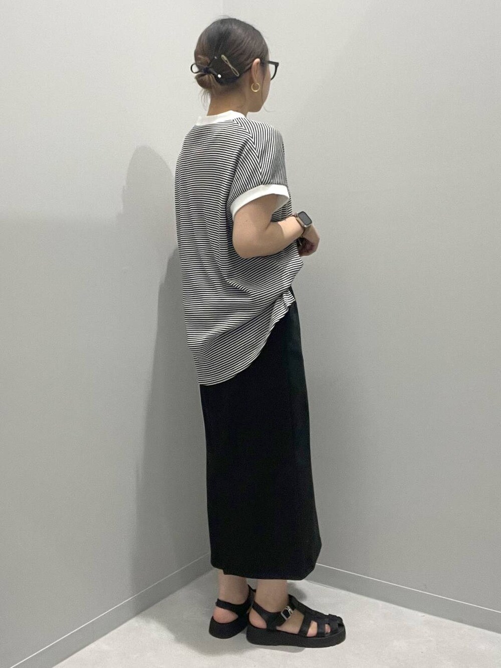 ブラック系のスカート、ホワイト系のTシャツ/カットソーを着用したレディースの夏コーディネートの2枚目の写真