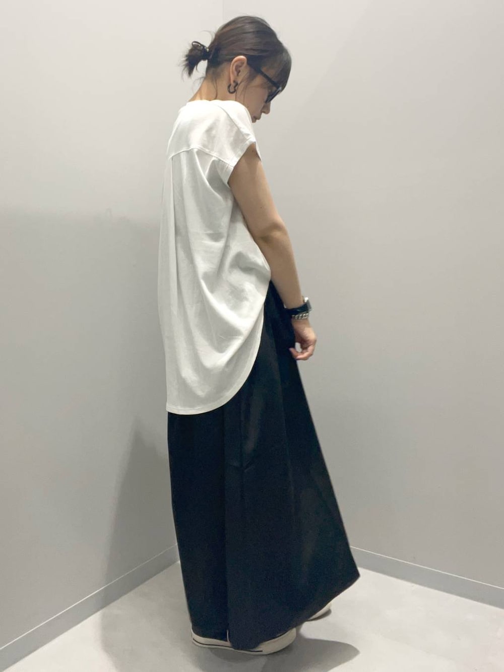 ブラック系のスカート、ホワイト系のTシャツ/カットソーを着用したレディースの夏コーディネートの2枚目の写真