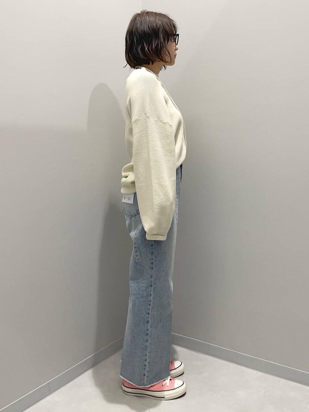 ホワイト系のニット/セーター、ホワイト系のショルダーバッグ、ブルー系のデニムパンツを着用したレディースの冬コーディネートの3枚目の写真