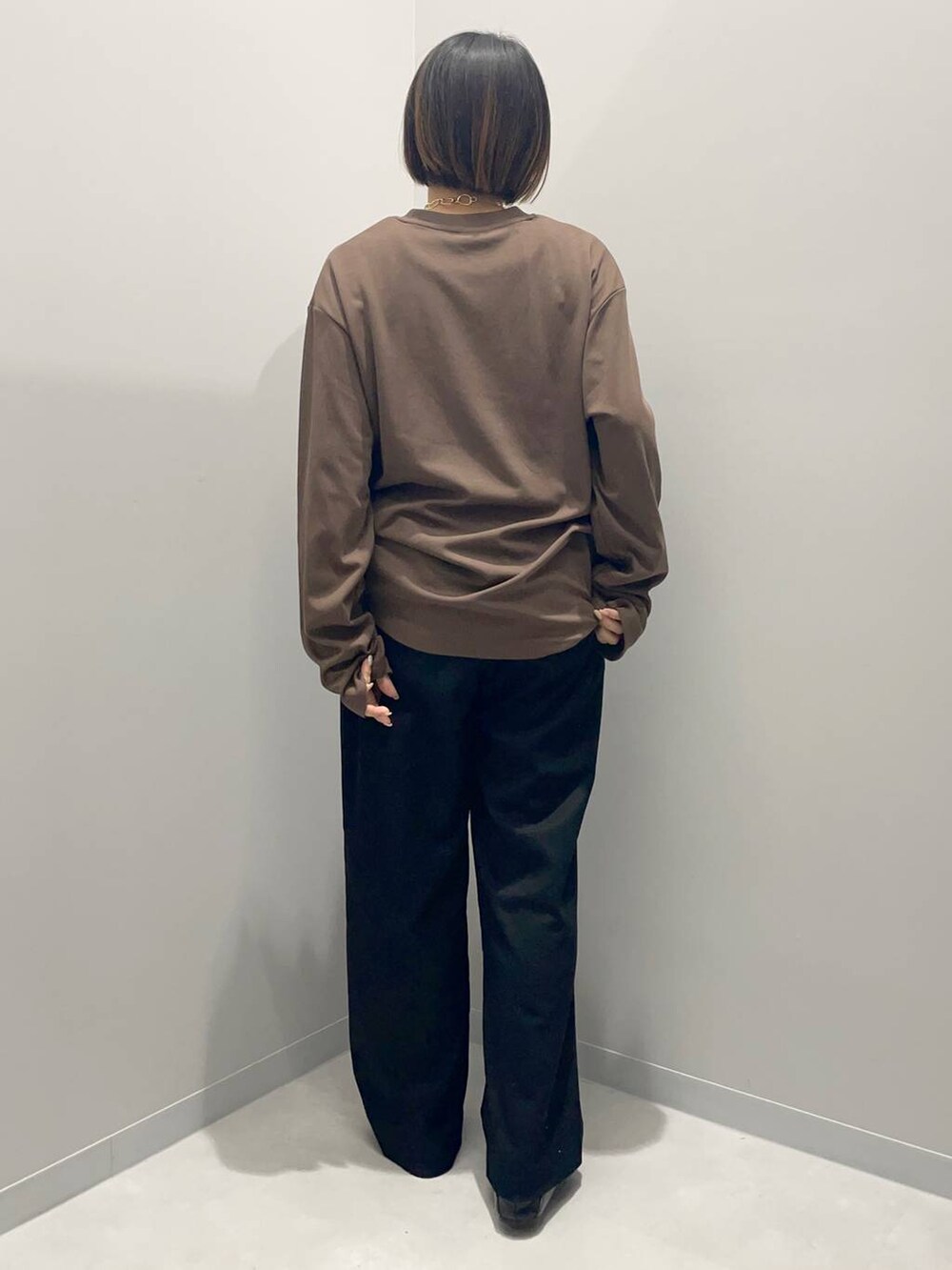 ブラック系のその他パンツ、ブラウン系のTシャツ/カットソー、ゴールド系のネックレスを着用したレディースの秋コーディネートの3枚目の写真