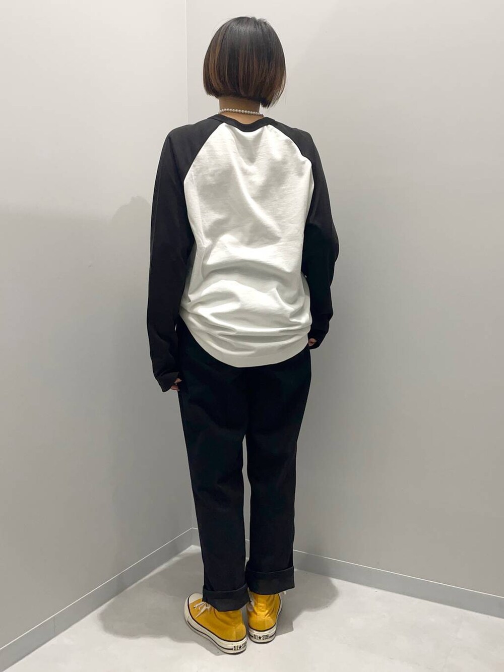 ブラック系のデニムパンツ、ホワイト系のTシャツ/カットソーを着用したレディースの秋コーディネートの2枚目の写真