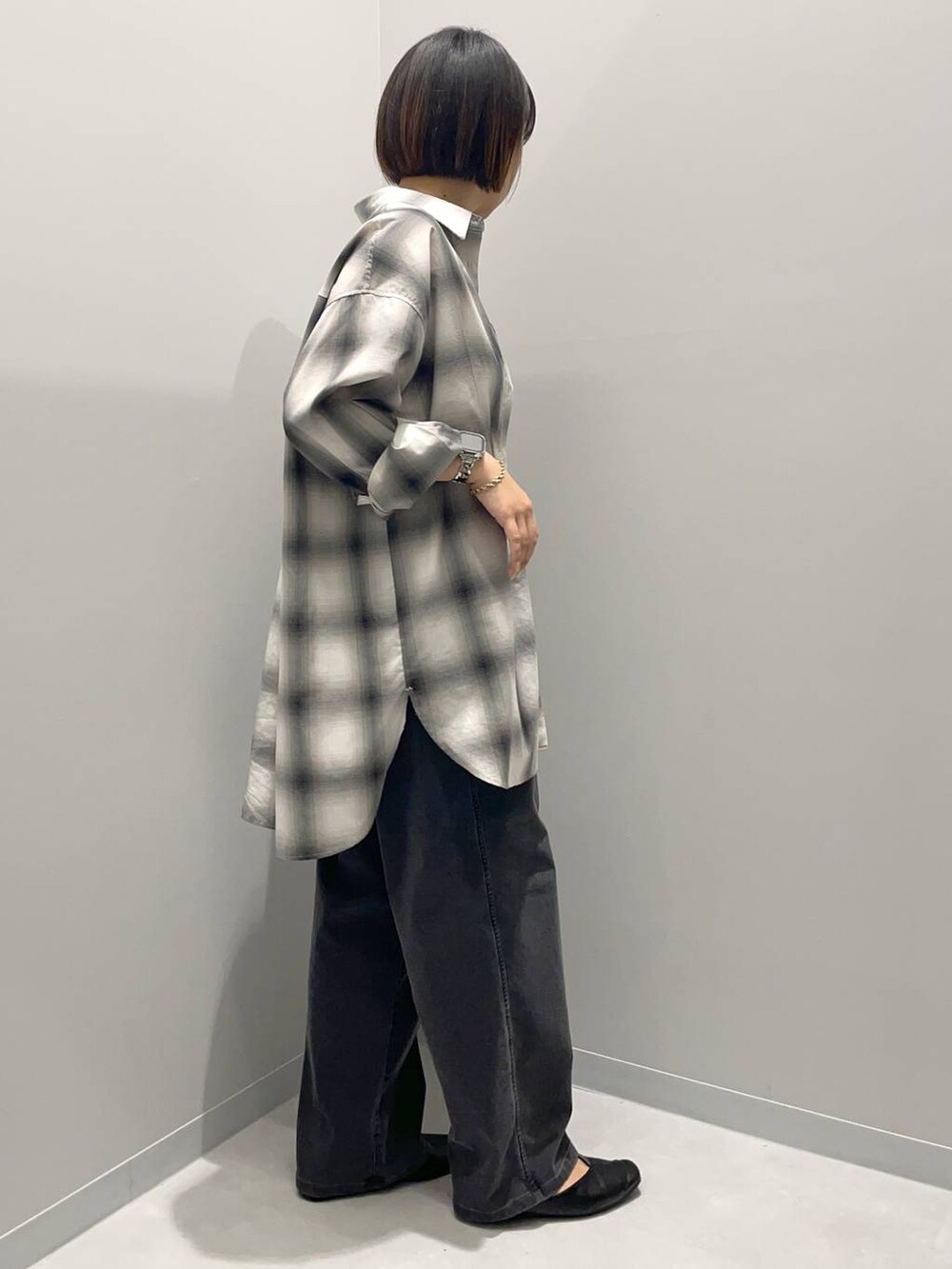 ブラック系のデニムパンツ、グレー系のシャツ/ブラウスを着用したレディースの秋コーディネートの3枚目の写真